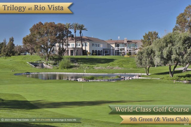 view of community featuring a lawn, view of golf course, and a water view