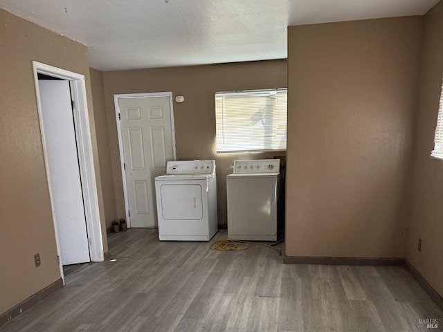 laundry room featuring light wood-style floors, laundry area, washer and clothes dryer, and baseboards