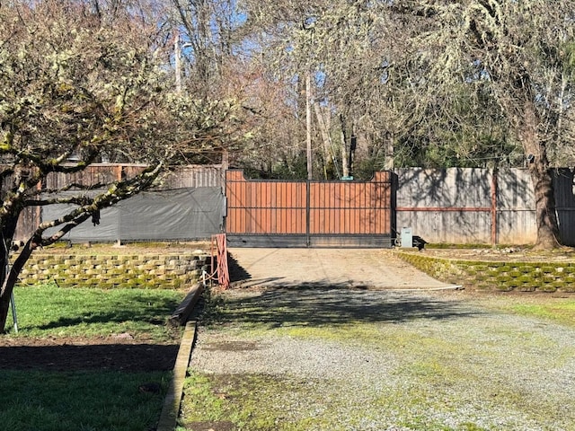 view of gate with fence and a lawn