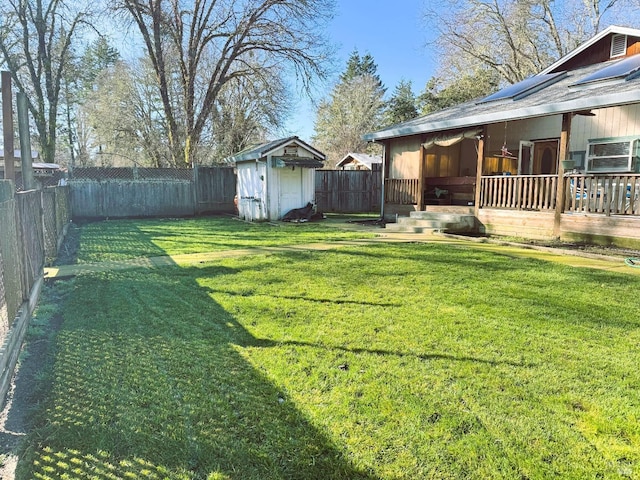 view of yard featuring a storage unit, an outdoor structure, and a fenced backyard