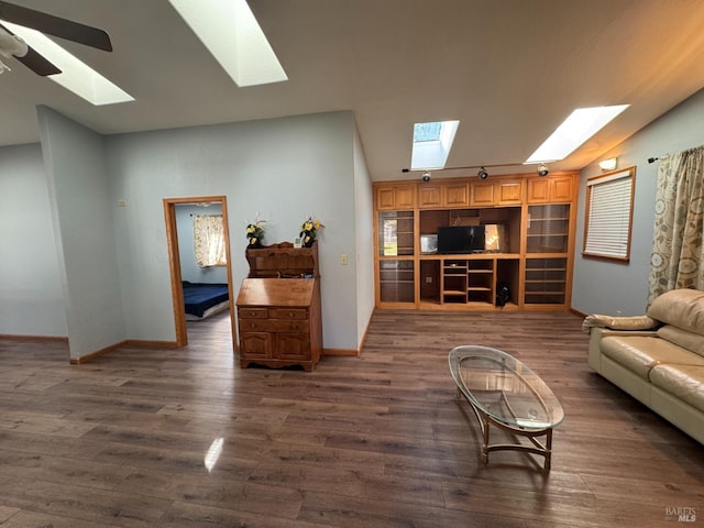 living room with a skylight, dark wood finished floors, and baseboards