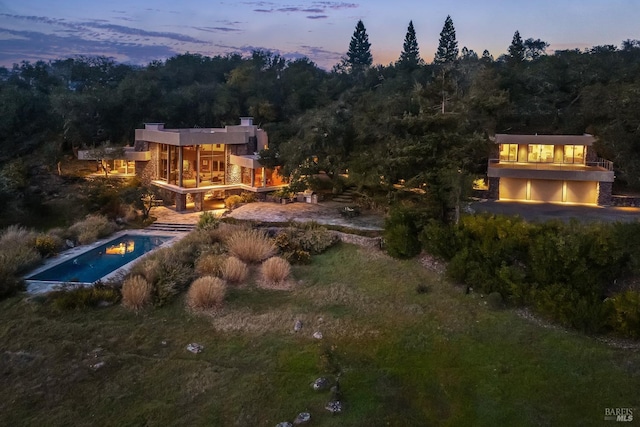 exterior space featuring stone siding and a view of trees