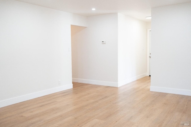 spare room with light wood-style floors, recessed lighting, and baseboards