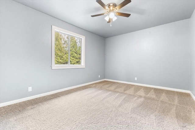 carpeted empty room featuring a ceiling fan and baseboards