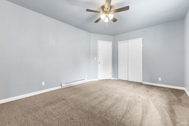 unfurnished bedroom with a baseboard heating unit, carpet flooring, a ceiling fan, and baseboards