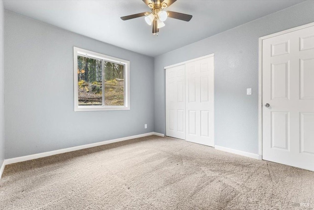 unfurnished bedroom with a ceiling fan, a closet, baseboards, and carpet flooring