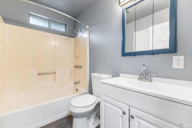 bathroom with toilet, wood finished floors, shower / tub combination, and vanity