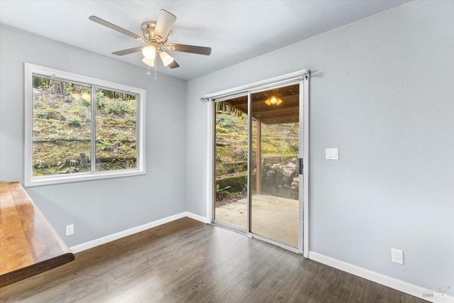 spare room with a healthy amount of sunlight, baseboards, and dark wood finished floors