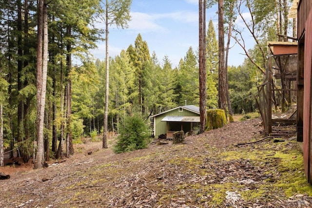 view of yard with a forest view and an outbuilding