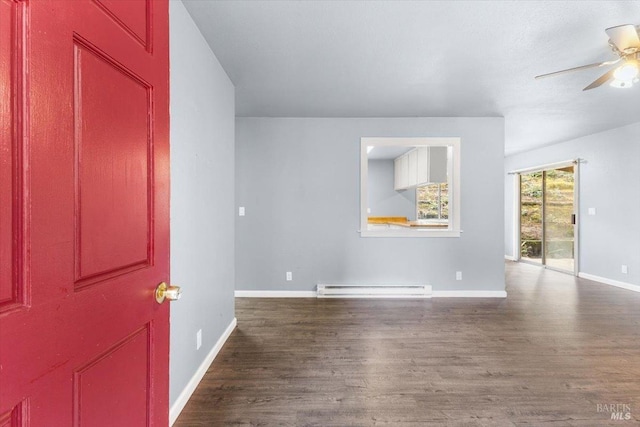 foyer entrance with baseboards, a baseboard heating unit, dark wood finished floors, and a ceiling fan