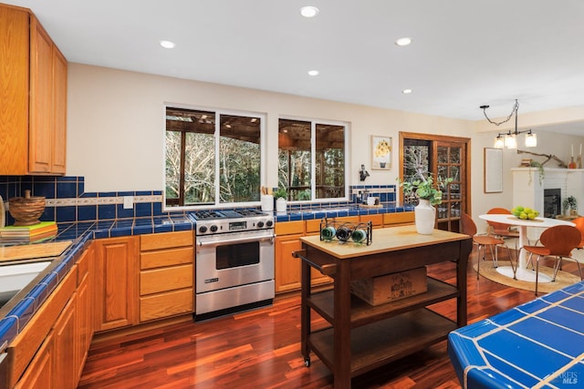 kitchen with tile countertops, gas range, backsplash, and dark wood-type flooring