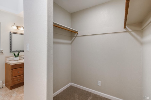 spacious closet featuring light carpet