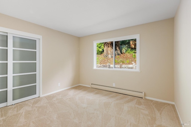 empty room featuring baseboards, a baseboard radiator, and light colored carpet