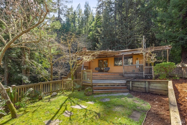 view of front of property featuring a front yard and a wooden deck