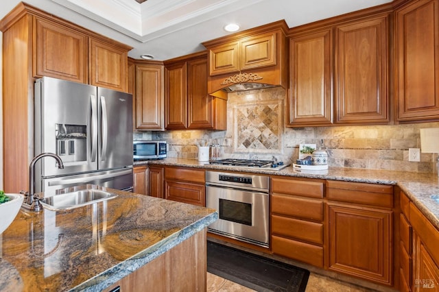 kitchen featuring appliances with stainless steel finishes, dark stone counters, and a sink