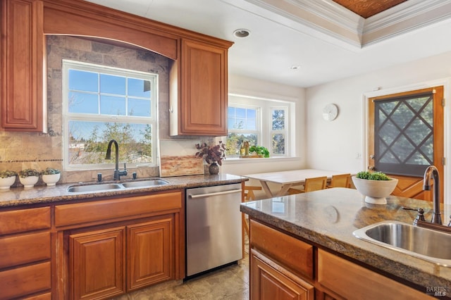 kitchen featuring a sink, backsplash, brown cabinetry, and stainless steel dishwasher