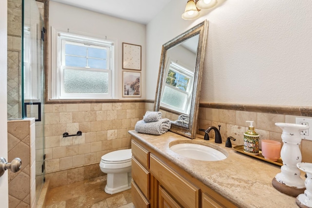 bathroom featuring a wainscoted wall, tile walls, toilet, a shower stall, and vanity