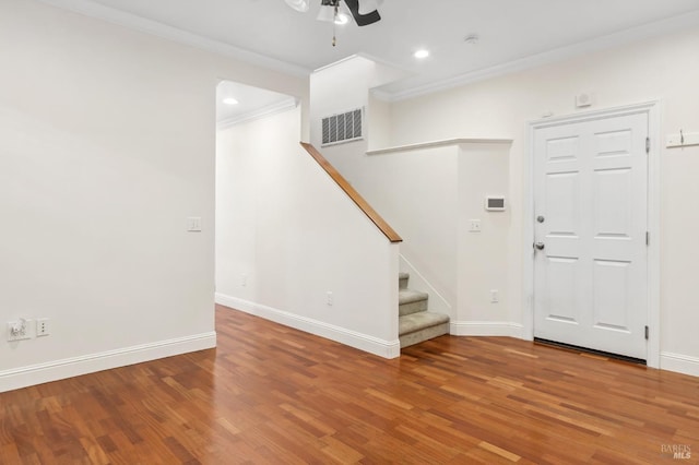 interior space with wood finished floors, visible vents, baseboards, stairs, and crown molding