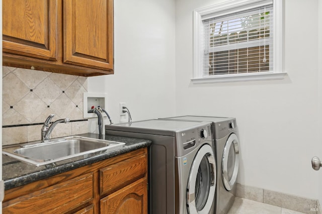 washroom featuring light tile patterned floors, cabinet space, a sink, and separate washer and dryer