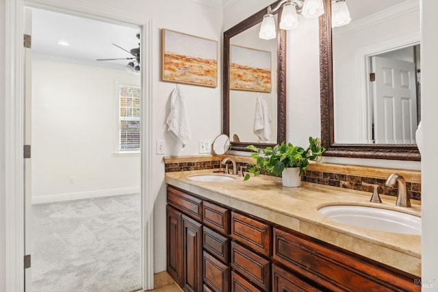 bathroom featuring double vanity, ornamental molding, a sink, and baseboards