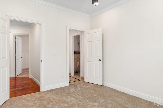 unfurnished bedroom featuring light colored carpet, crown molding, and baseboards