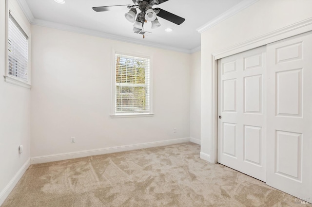 unfurnished bedroom featuring light carpet, a closet, baseboards, and crown molding