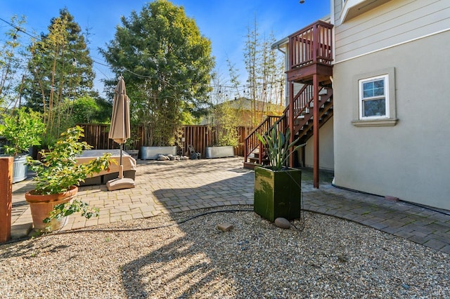 view of yard with a patio area, a hot tub, stairs, and a fenced backyard