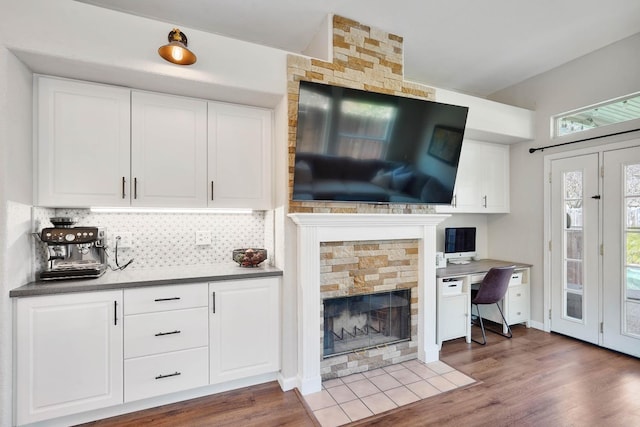 living area featuring a fireplace, built in desk, and wood finished floors