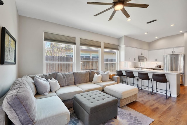 living area featuring light wood finished floors, visible vents, ceiling fan, vaulted ceiling, and recessed lighting