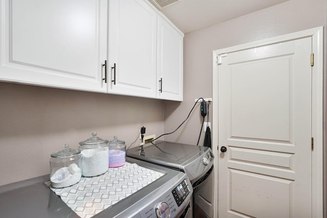 laundry room featuring visible vents, washing machine and clothes dryer, and cabinet space