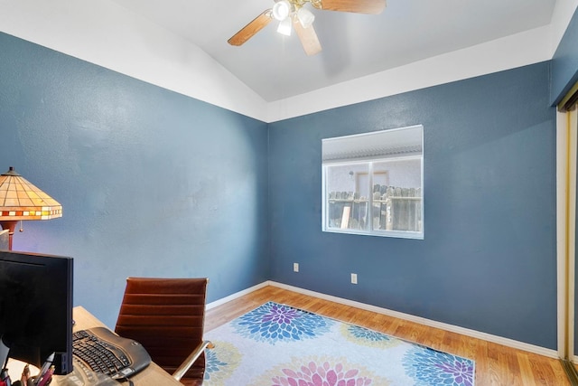 home office featuring vaulted ceiling, wood finished floors, a ceiling fan, and baseboards