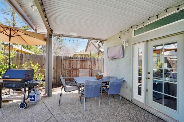 view of patio / terrace featuring outdoor dining space, fence, and a grill