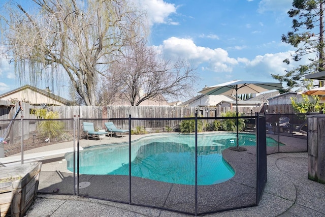 view of pool with a fenced backyard, a diving board, a fenced in pool, and a patio