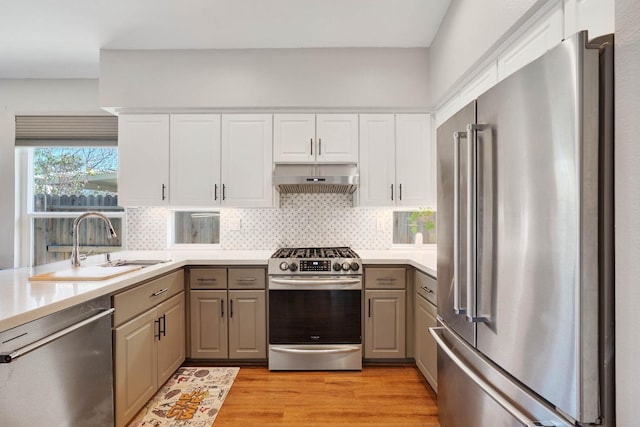 kitchen featuring stainless steel appliances, light wood-style flooring, under cabinet range hood, and gray cabinetry