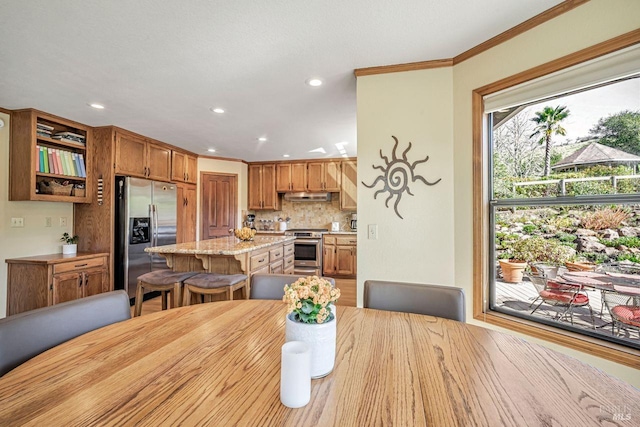 dining room with ornamental molding and recessed lighting