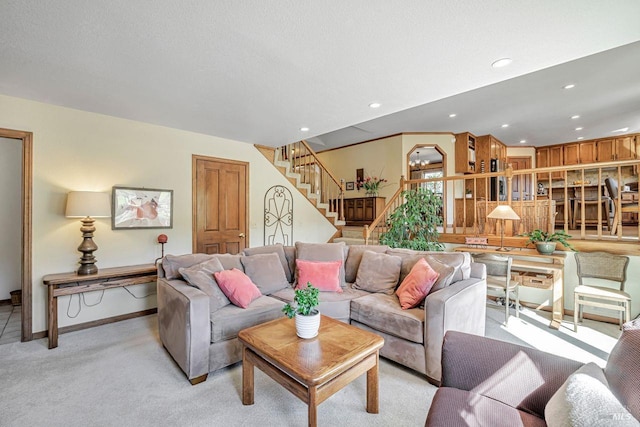 living area featuring a textured ceiling, stairway, light colored carpet, and recessed lighting