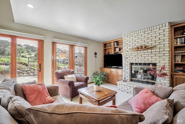 living area with built in features, plenty of natural light, a fireplace, and a textured ceiling