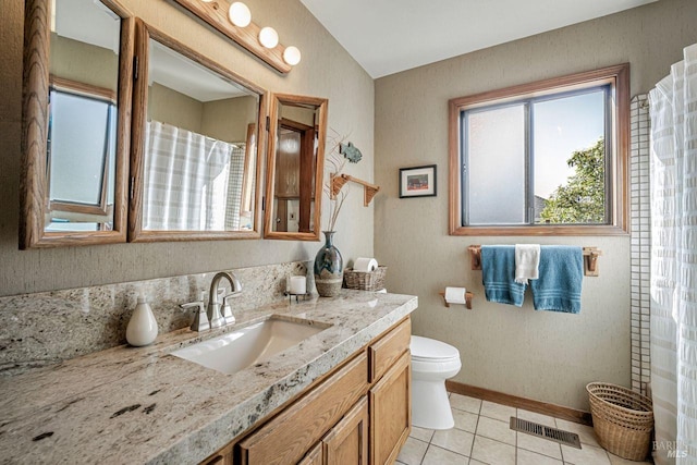 bathroom featuring tile patterned flooring, toilet, vanity, visible vents, and baseboards