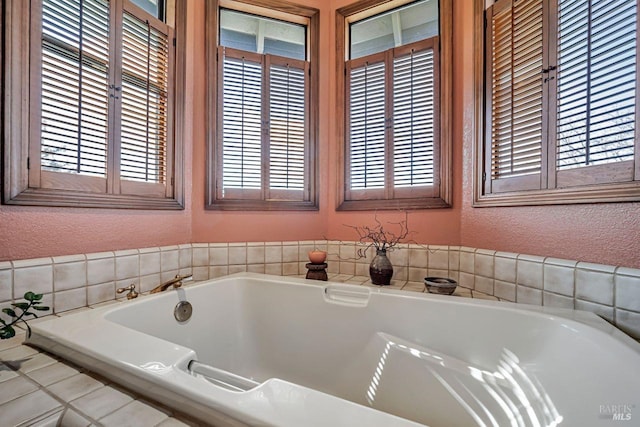 bathroom with a bath and a textured wall