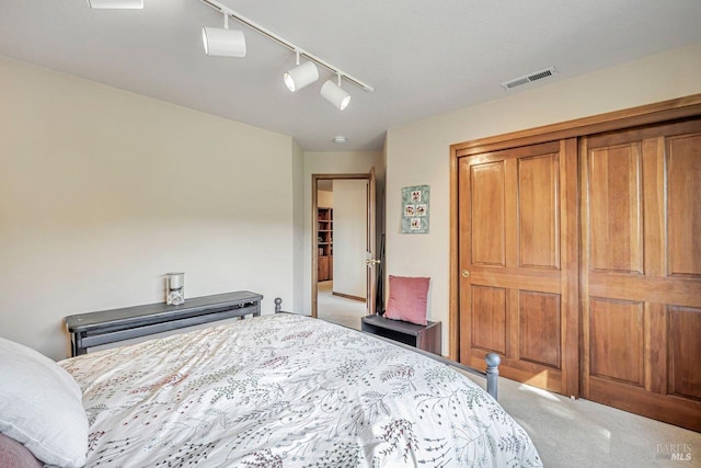 carpeted bedroom featuring a closet and visible vents