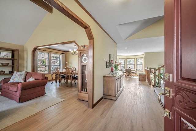 entryway with vaulted ceiling, plenty of natural light, and light wood-style flooring