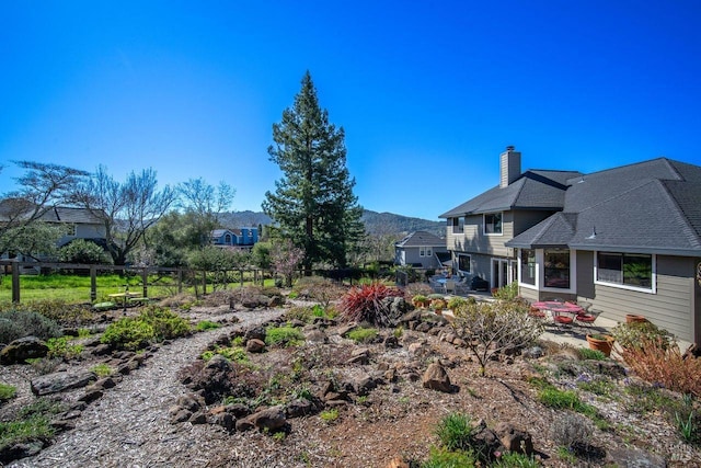 view of yard featuring a patio area, fence, and a mountain view