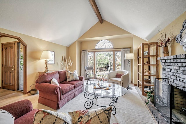 living area featuring lofted ceiling with beams, a fireplace, and wood finished floors