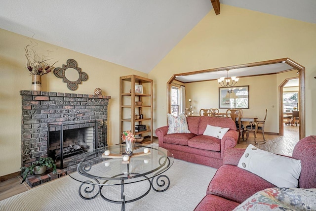 living room featuring a healthy amount of sunlight, a fireplace, beam ceiling, and wood finished floors