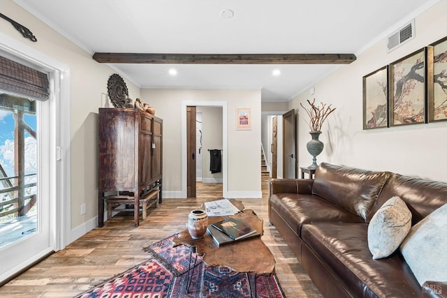 living room featuring light wood-type flooring, visible vents, beamed ceiling, and baseboards