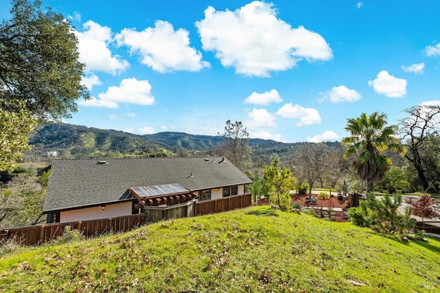 exterior space featuring a shingled roof and a mountain view