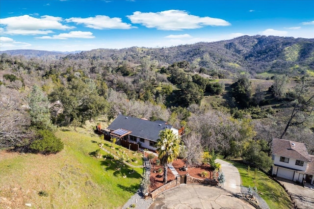 drone / aerial view featuring a mountain view and a view of trees