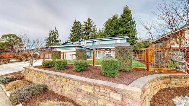 view of front of house featuring concrete driveway and fence