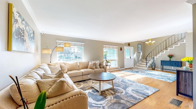 living area featuring crown molding, stairway, wood finished floors, a chandelier, and baseboards