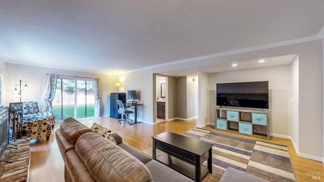 living room featuring light wood-style floors, ornamental molding, and baseboards